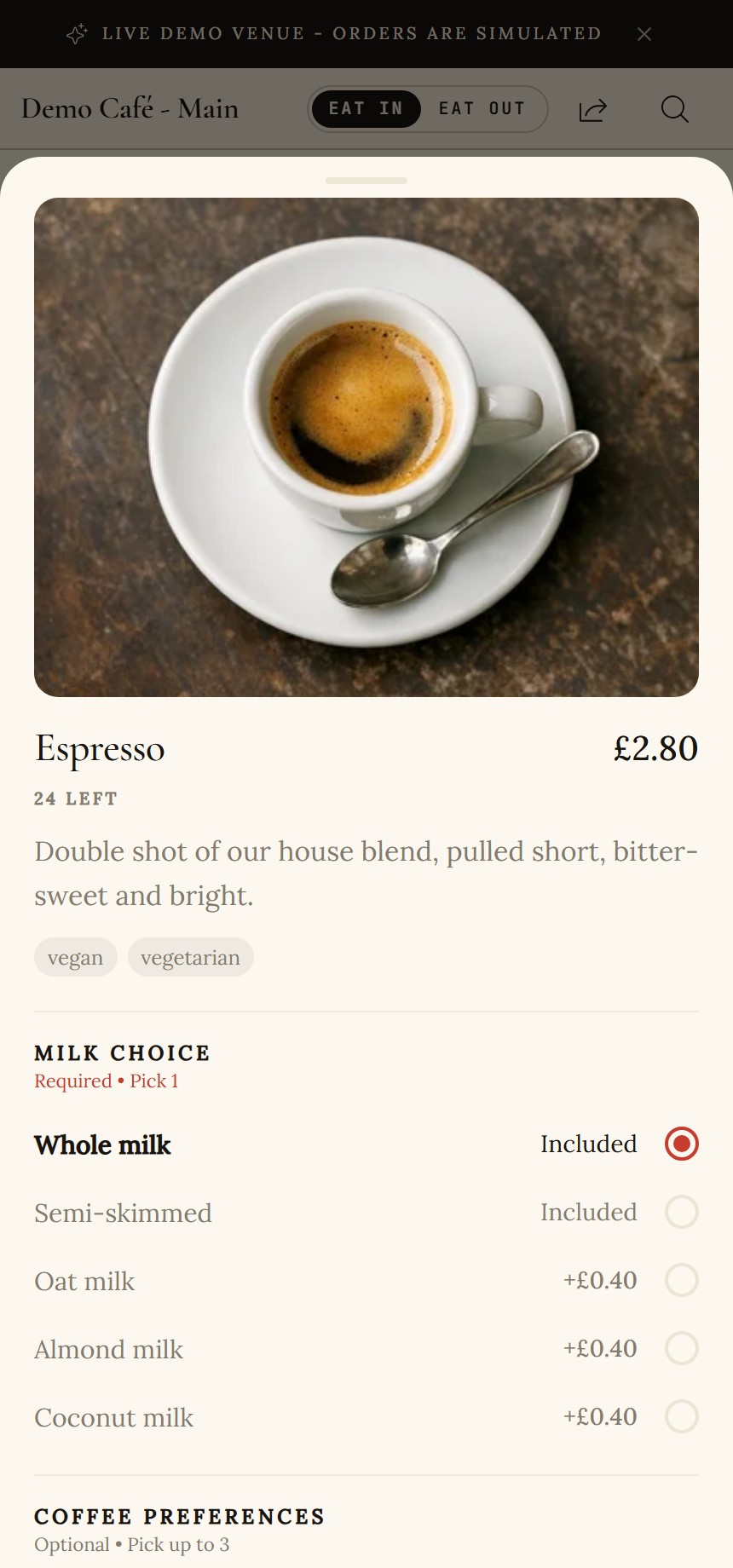 Item dialog for an espresso: large photo, price, stock count, description, vegan and vegetarian badges, a Required Pick 1 milk choice group with radio buttons, and an optional preferences group below
